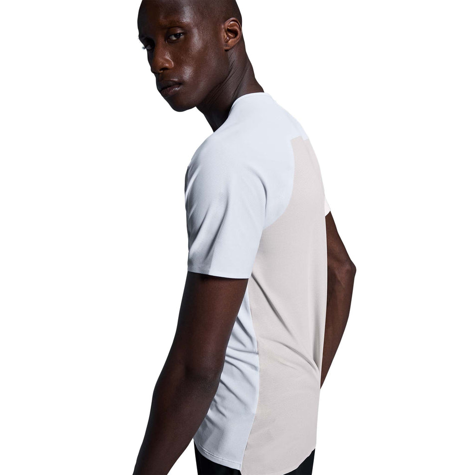 Side view of a model wearing the On Men's Performance-T in the White/Silver colourway. (8715745951906)