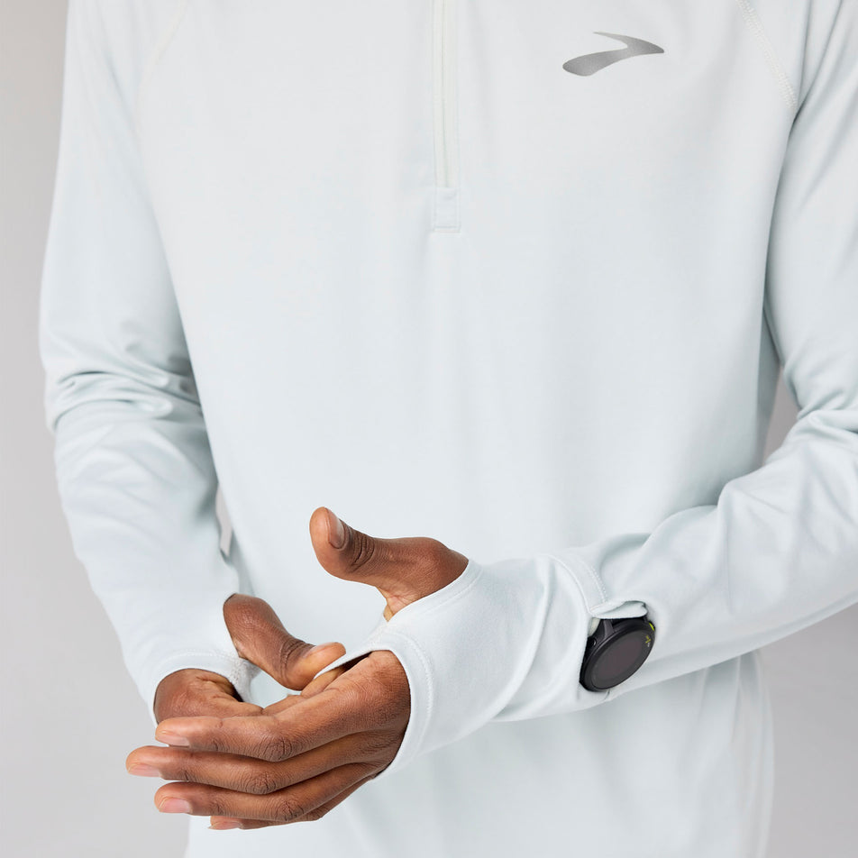 A model demonstrating the thumbhole loops on the Brooks Men's Dash 1/4 Zip 3.0 in the Smoke colourway. (8718750580898)