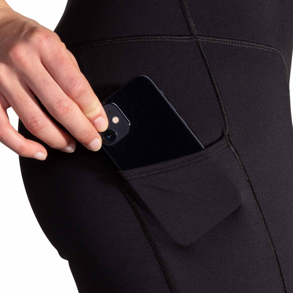 A model demonstrating the drop-in pocket on the side of the Brooks Women's Spark 8