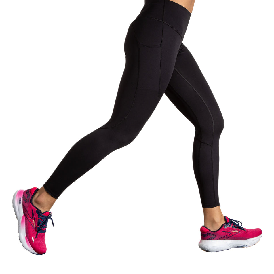 Side view of a model wearing the Brooks Women's Spark Tight in the Black colourway. (8718911406242)
