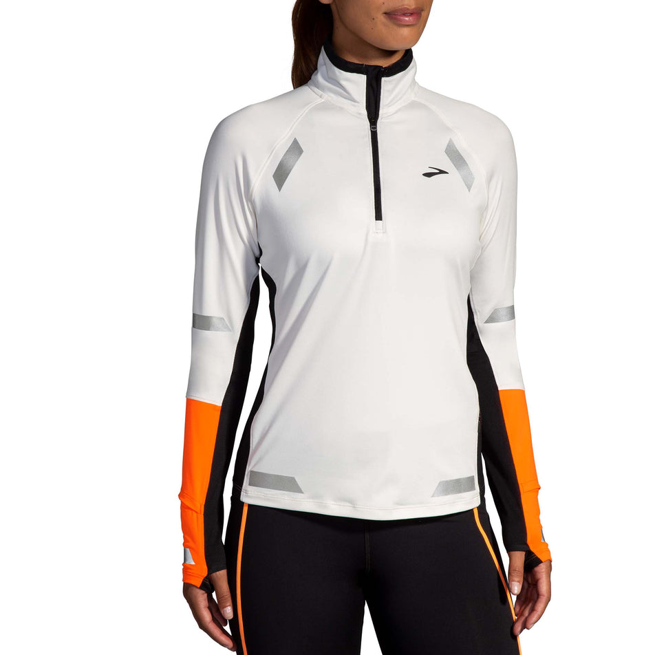 Front view of a model wearing the Brooks Women's Run Visible 1/2 Zip 2.0 in the Ecru/Fluoro Flash/Black colourway. Model is also wearing Brooks tights.(8499447333026)