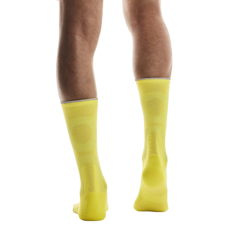 Back view of a model wearing a pair of On Unisex Elite Run Sock High in the Lime colourway. (8717355712674)