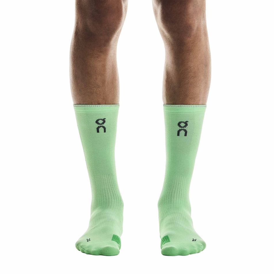 Front view of a model wearing the On Unisex Performance Run Sock High in the Honeydew/Parsley colourway. (8717316260002)