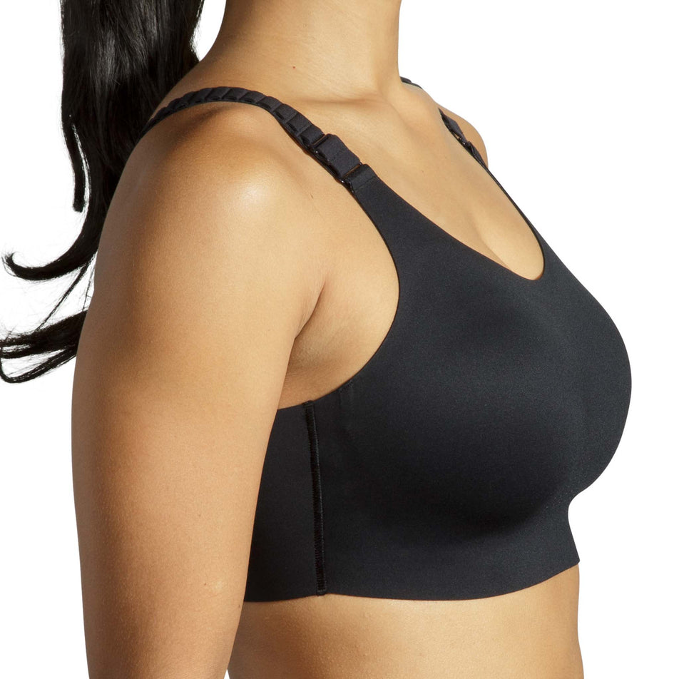 Close-up of a model wearing a Brooks Women's Scoopback 2.0 Sports Bra in the Black colourway. Side view. (8636841099426)