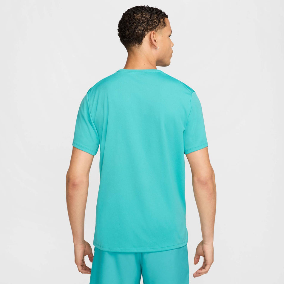 Back view of a model wearing the Nike Men's Miler Dri-FIT UV Short-Sleeve Running Top in the Dusty Cactus/Reflective Silver colourway. (8562855116962)