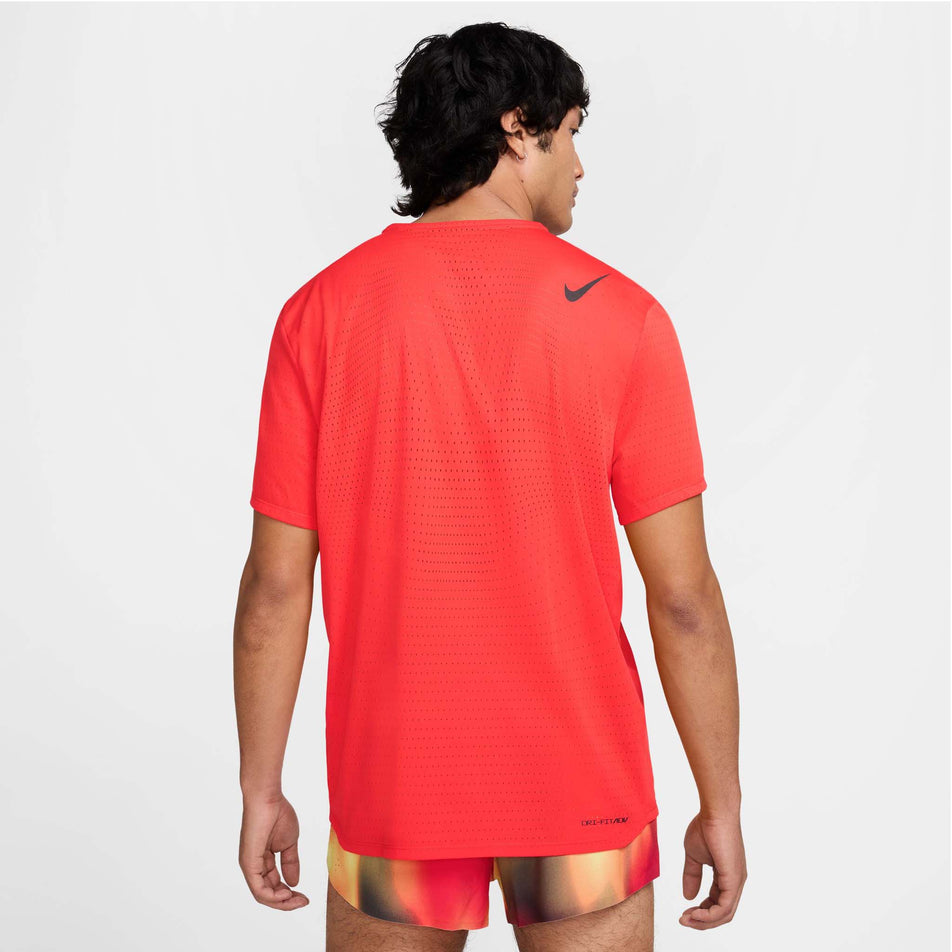 Back view of a model wearing the Nike Men's AeroSwift Dri-FIT ADV Short-Sleeve Running Top in the Light Crimson/Black colourway. (8560409706658)