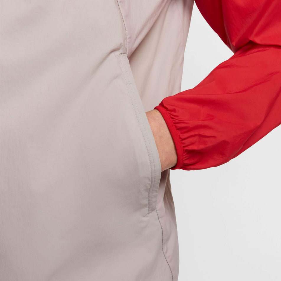 Close-up of the left-hand pocket on a Nike Men's Stride Repel UV Running Jacket in the University Red/Reflective Silver colourway. Jacket is being worn by a model. (8591132655778)