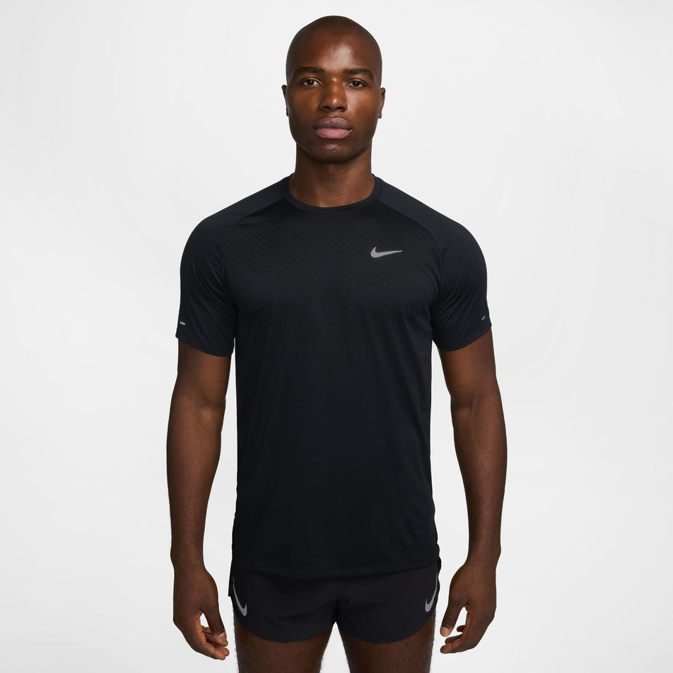 Front view of a model wearing the Nike Men's Stride Dri-FIT ADV Short-Sleeve Running Top in the Black/Reflective Silver colourway. (8560160735394)