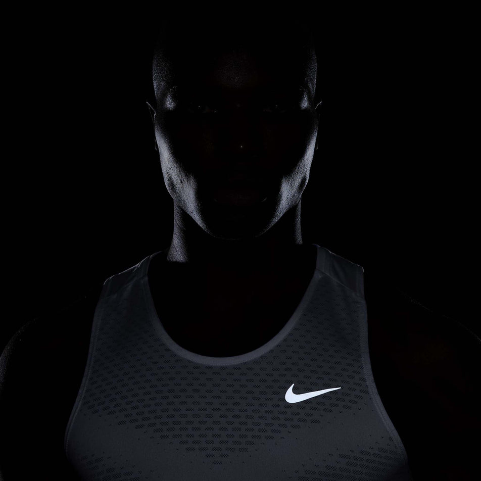 The reflective swoosh on the front of the Nike Men's Stride Dri-FIT ADV Running Tank Top in the White/Reflective Silver colourway. (8620702433442)