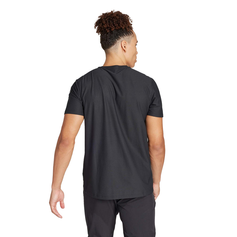 Back view of a model wearing the adidas Men's Own The Run Base Tee in the Black colourway. (8566972317858)