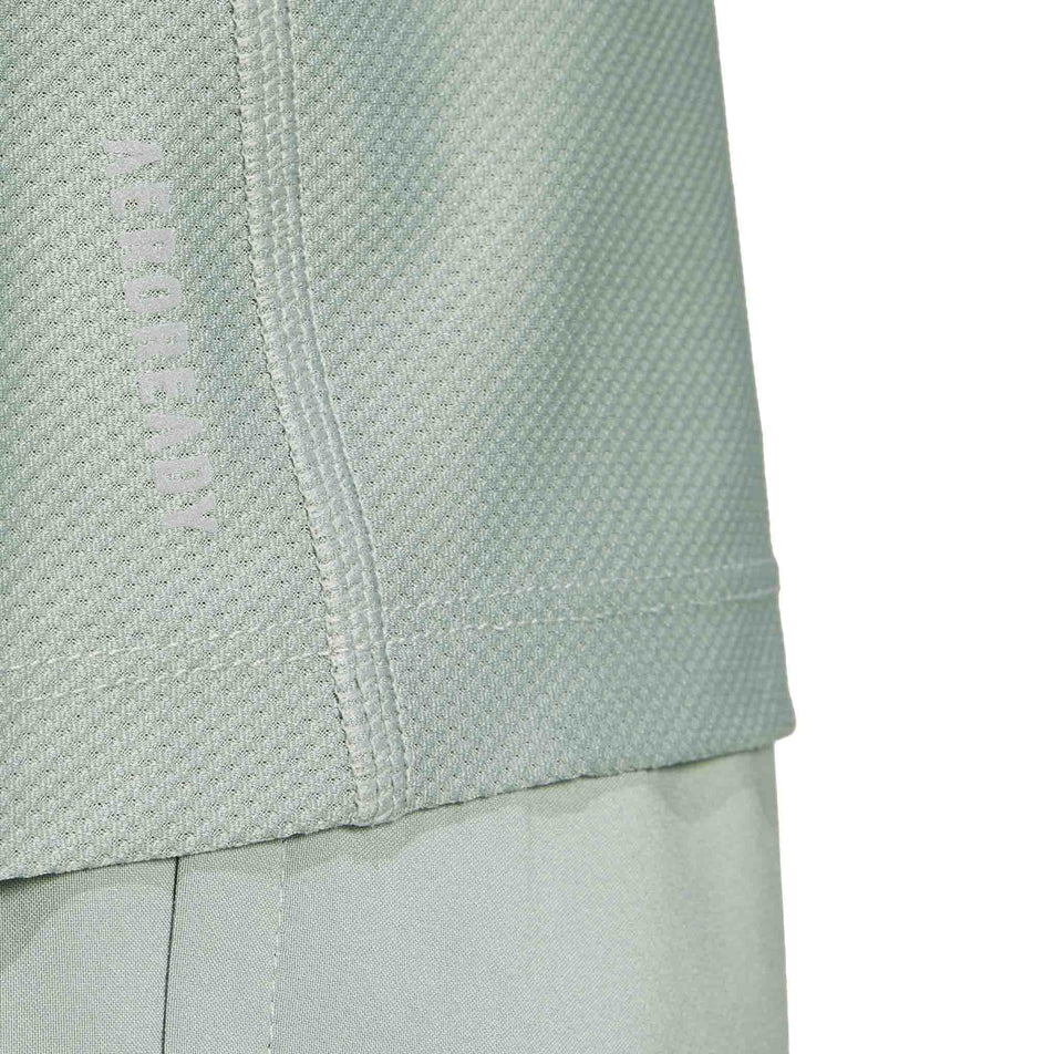 The AEROREADY logo on the adidas Men's Own The Run Base Tee in the Silver Green colourway. (8566974873762)