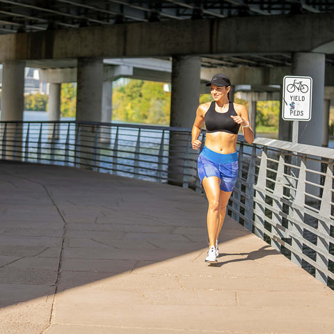 Women running under bridge in brooks bra
