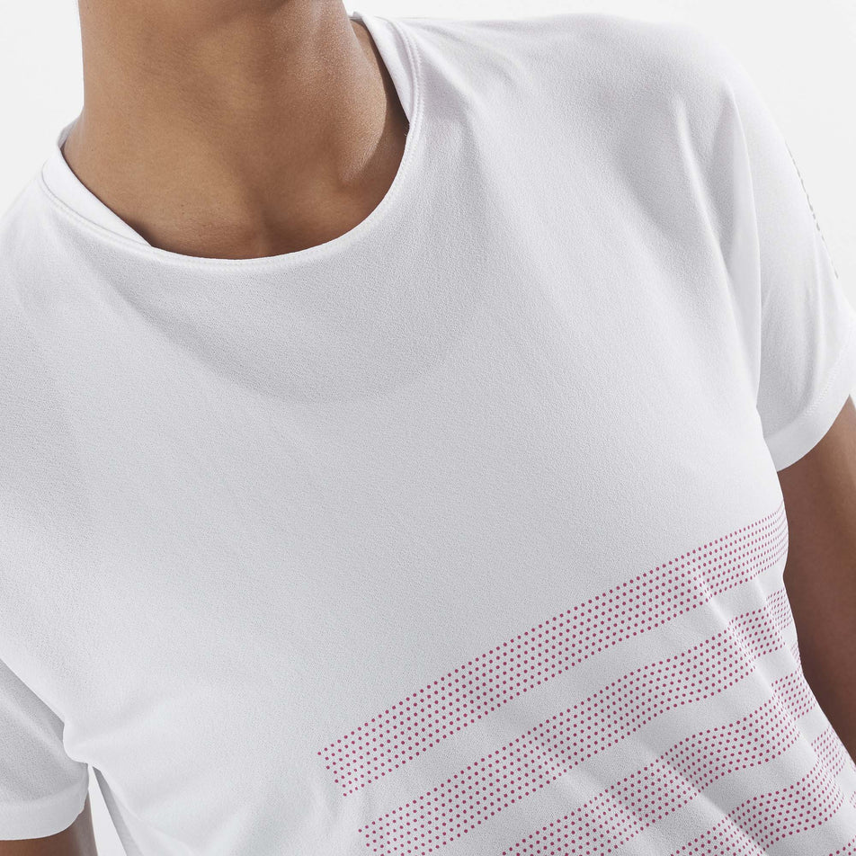 Close-up front view of a model wearing a Salomon Women's Sense Aero GFX Short Sleeve Tee in the White/Beetroot Purple colourway. (8157870850210)