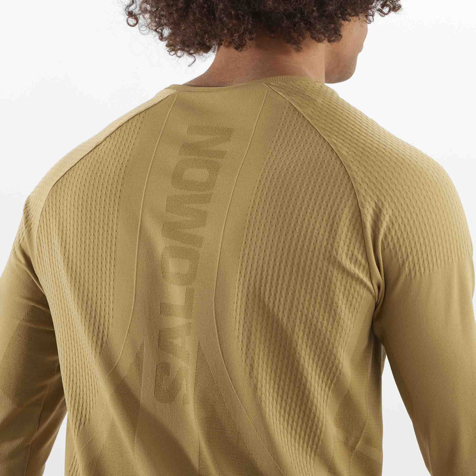 Close-up back view of the Salomon Men's Aero Seamless Long-Sleeve T-Shirt in the Antique Bronze colourway. The top is being worn by a mode.  (8509564846242)