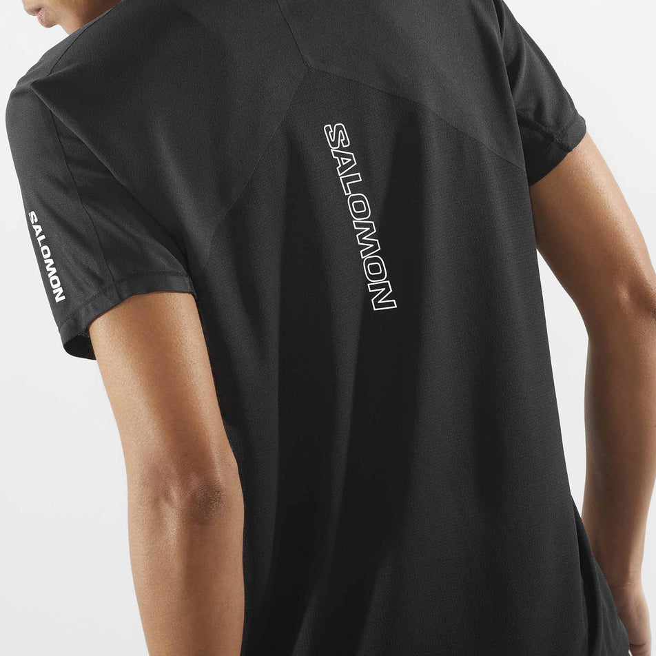 Close-up view of the back of a Salomon Women's Sense Aero Short Sleeve T-Shirt in the Deep Black colourway. Top is being worn by a model. (8462977695906)