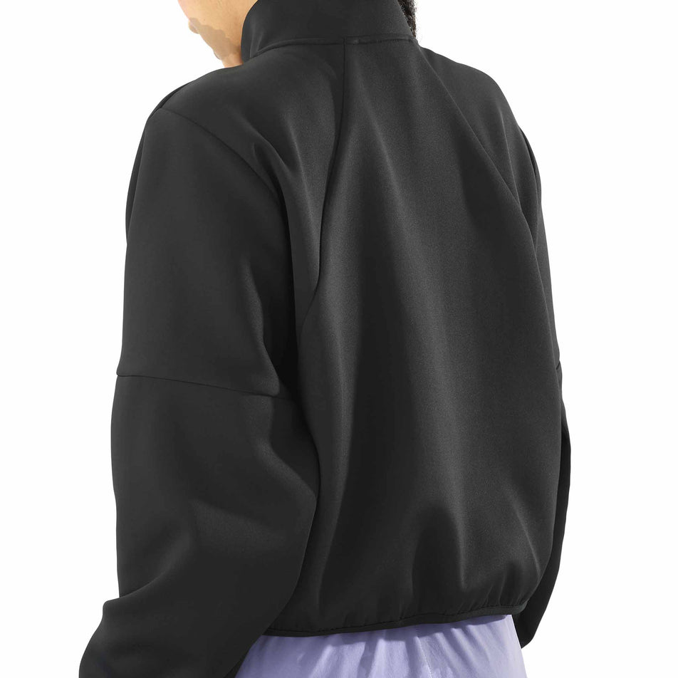 Back view of a model wearing the Salomon Women's SHKout Half Zip Midlayer in the Deep Black colourway. (8575544721570)