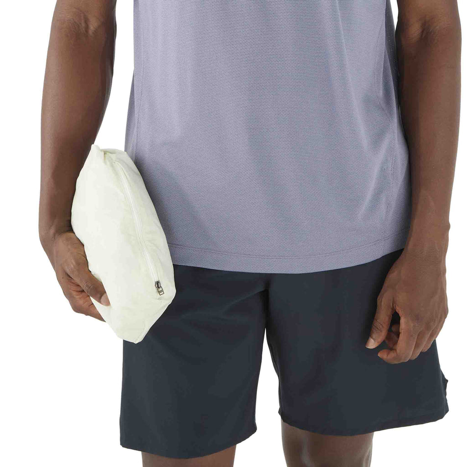 The Salomon Men's SHKout Fly Wind Jacket in the Icicle colourway stowed away into a pocket. (8575585222818)