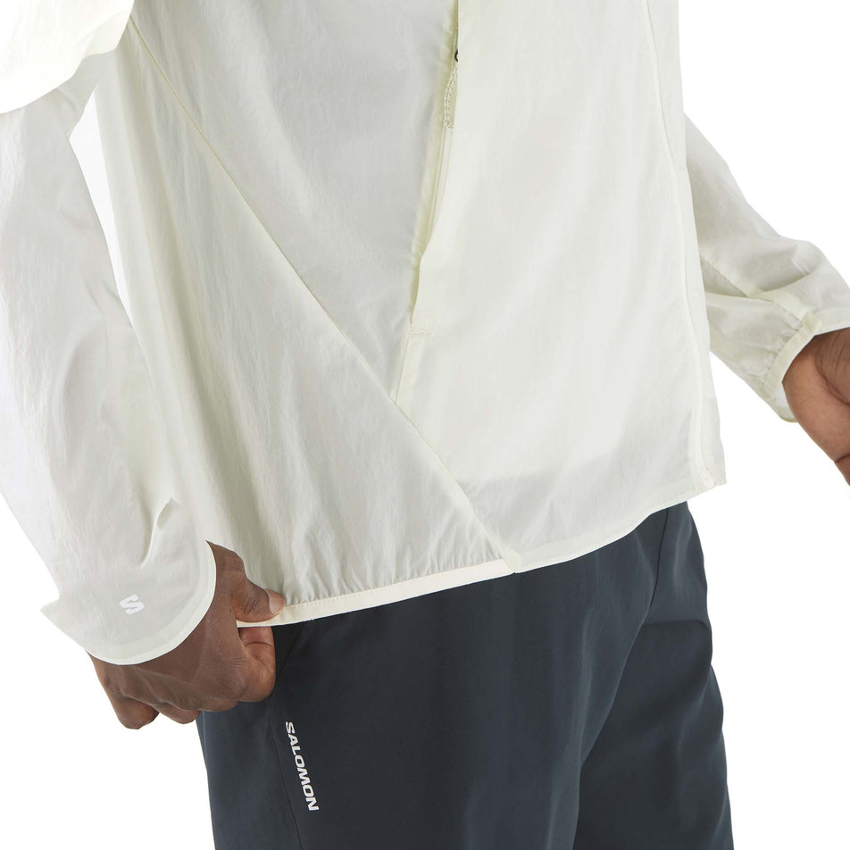 Side view of a model wearing the Salomon Men's SHKout Fly Wind Jacket in the Icicle colourway. (8575585222818)