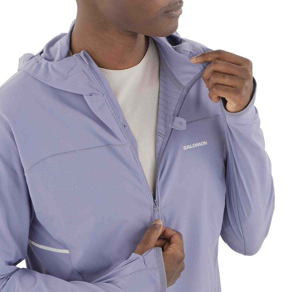 A model demonstrating the zip on the front of the Salomon Men's Sense Aero Hybrid Midlayer Jacket with Hood in the Blue Granite colourway. (8575574245538)