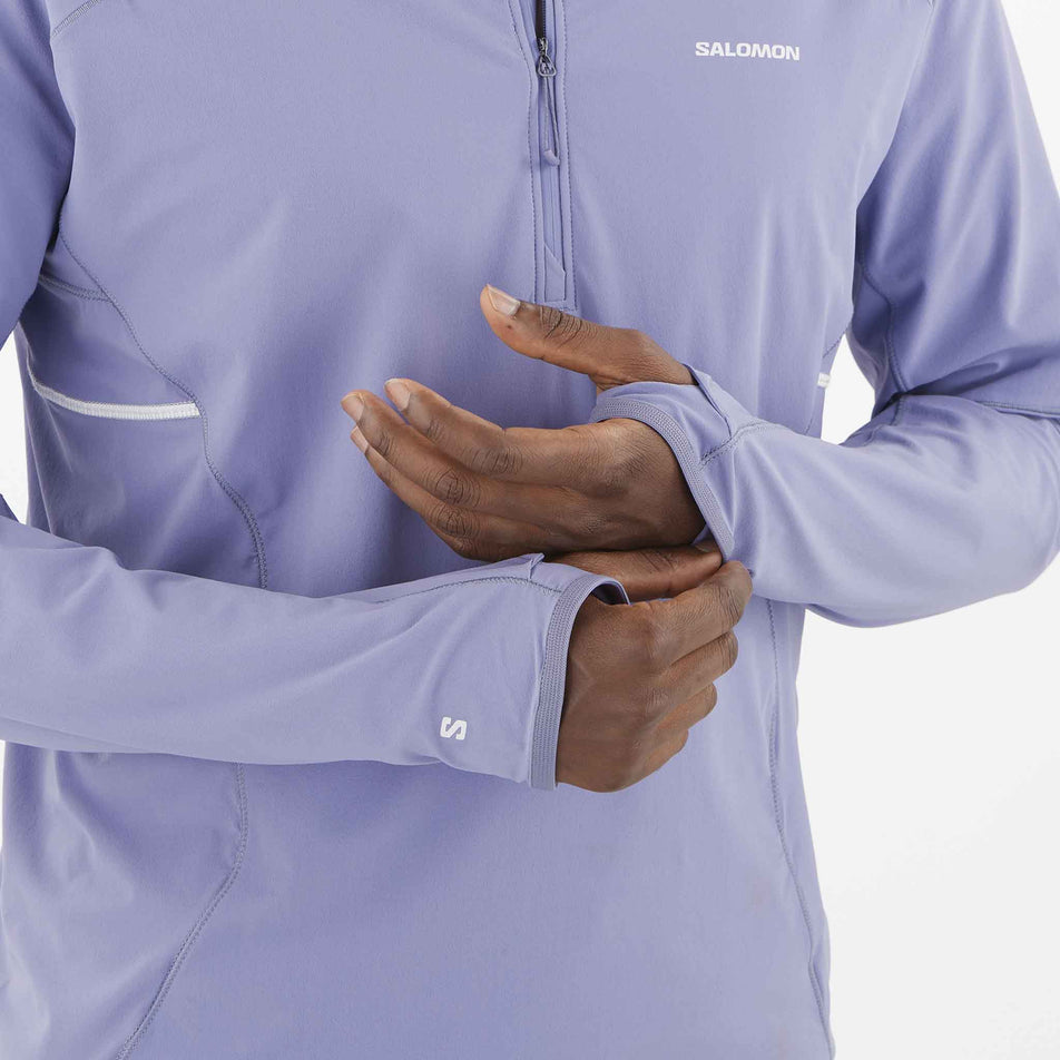 A model demonstrating the thumb loops on the sleeves of the Salomon Men's Sense Aero Hybrid Midlayer Jacket with Hood in the Blue Granite colourway. (8575574245538)