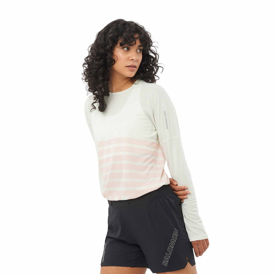 Front view of a model wearing the Salomon Women's Sense Aero Graphic Long Sleeve T-Shirt in the Icicle/Neon Flame colourway. (8574193696930) 