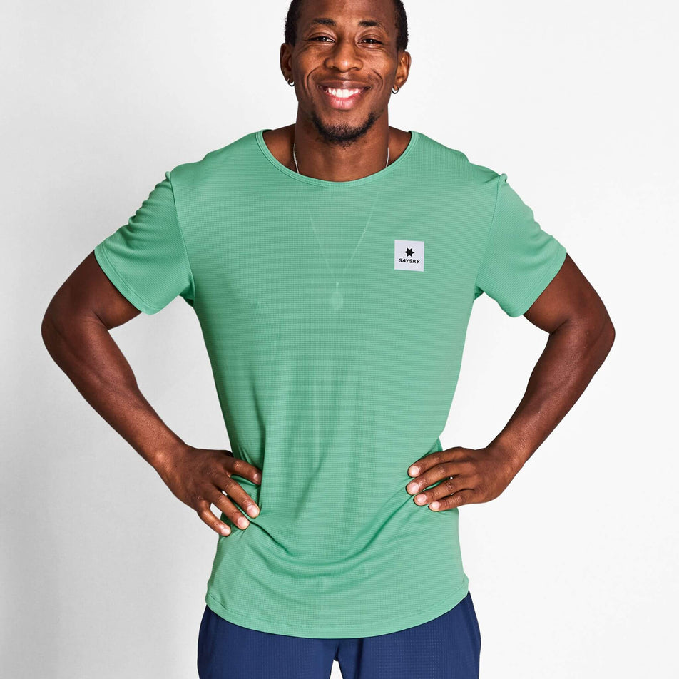 Front view of a model wearing a SAYSKY Men's Reactive Flow T-Shirt in the Green AOP colourway. Model is also wearing shorts. (8628407533730)