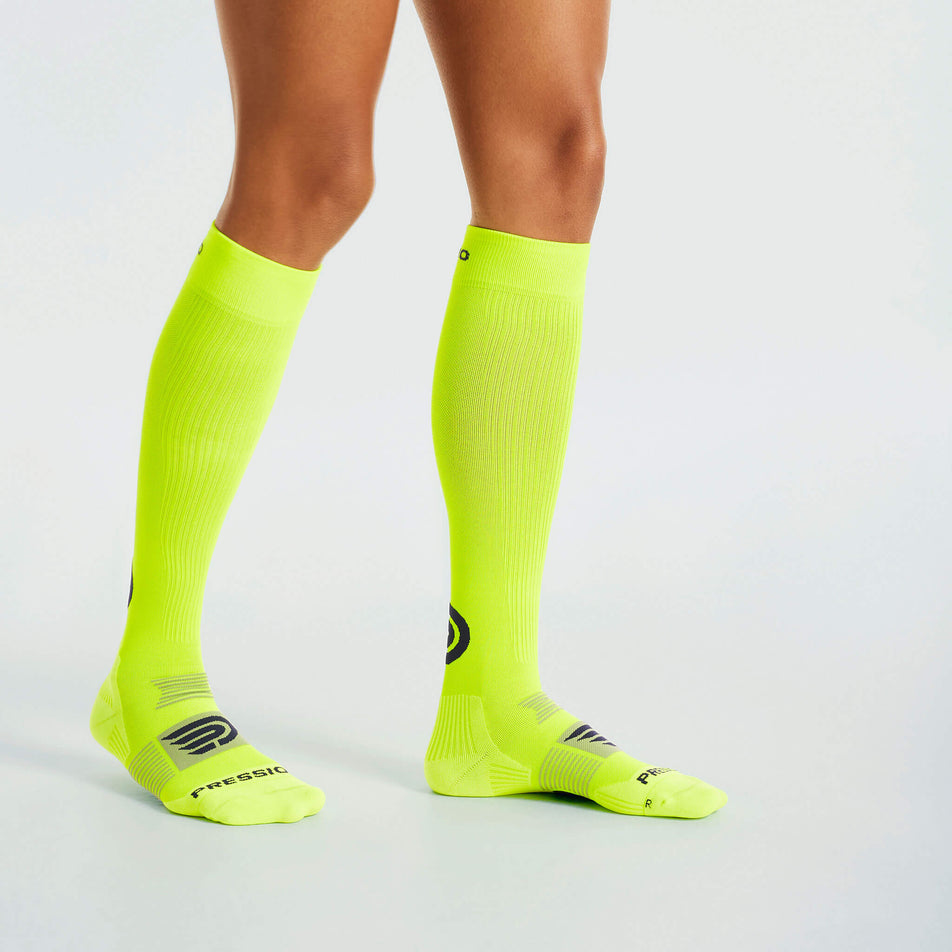 Side view of a model wearing the Pressio Unisex EQ Compression Socks in the Yellow/Navy colourway.  (8341599781026)