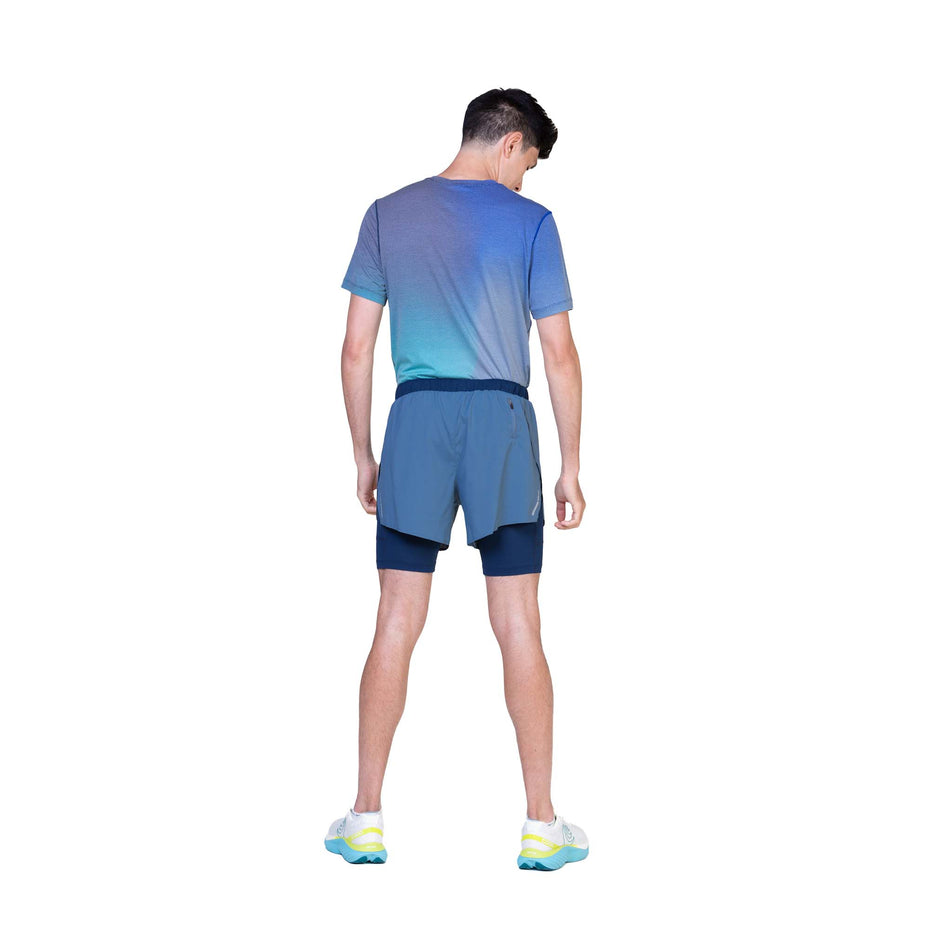 Back view of a model wearing the Ronhill Men's Tech Race Twin Short in Lake/Dark Navy colourway. (8565238464674)