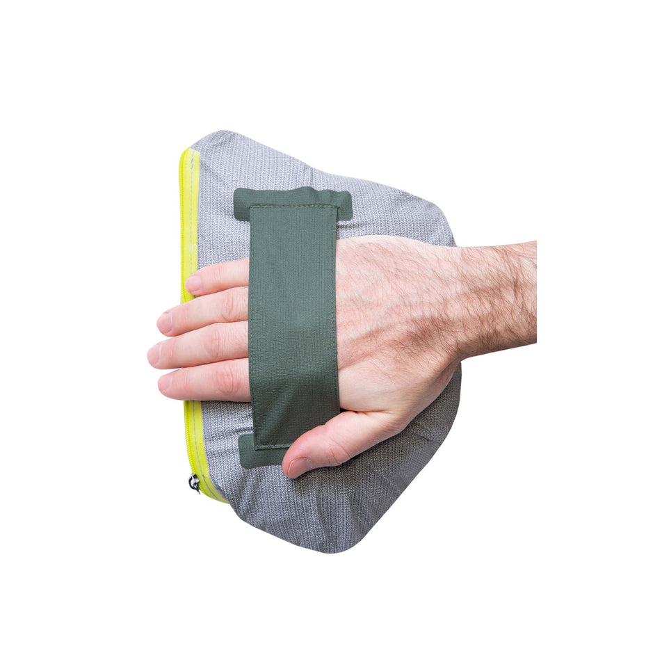 A model demonstrating that, once a Ronhill Men's Tech Fortify Jacket has been packed into its chest pocket, it can be carried in your hand - with the help of a strap.  (8470624895138)