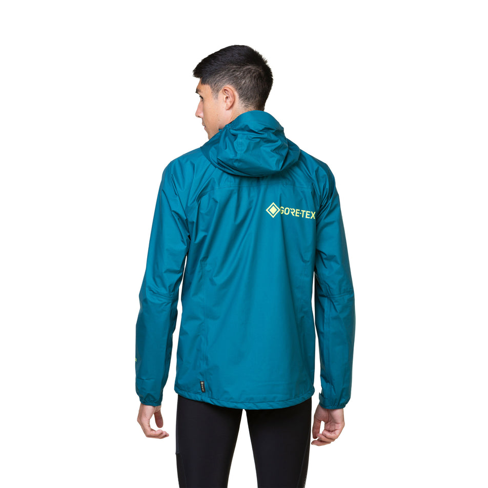 Back view of a model wearing a Ronhill Men's Tech GORE-TEX Mercurial Jacket in the Deep Teal/Acid colourway. Model is also wearing leggings. (8470598418594)