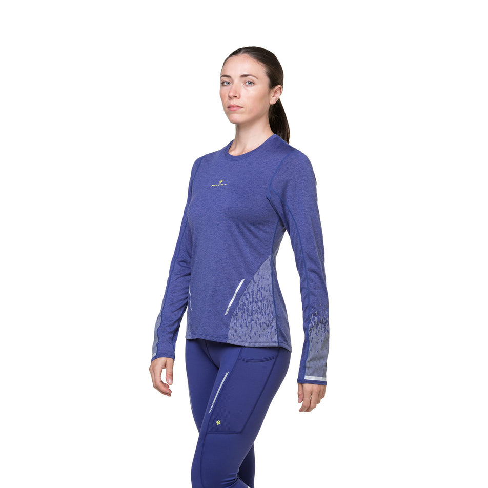 Front view of a model wearing a Ronhill Women's Tech Reflect L/S Tee in the Deep Ocean/Reflect colourway. Model is also wearing tights. (8489718874274)