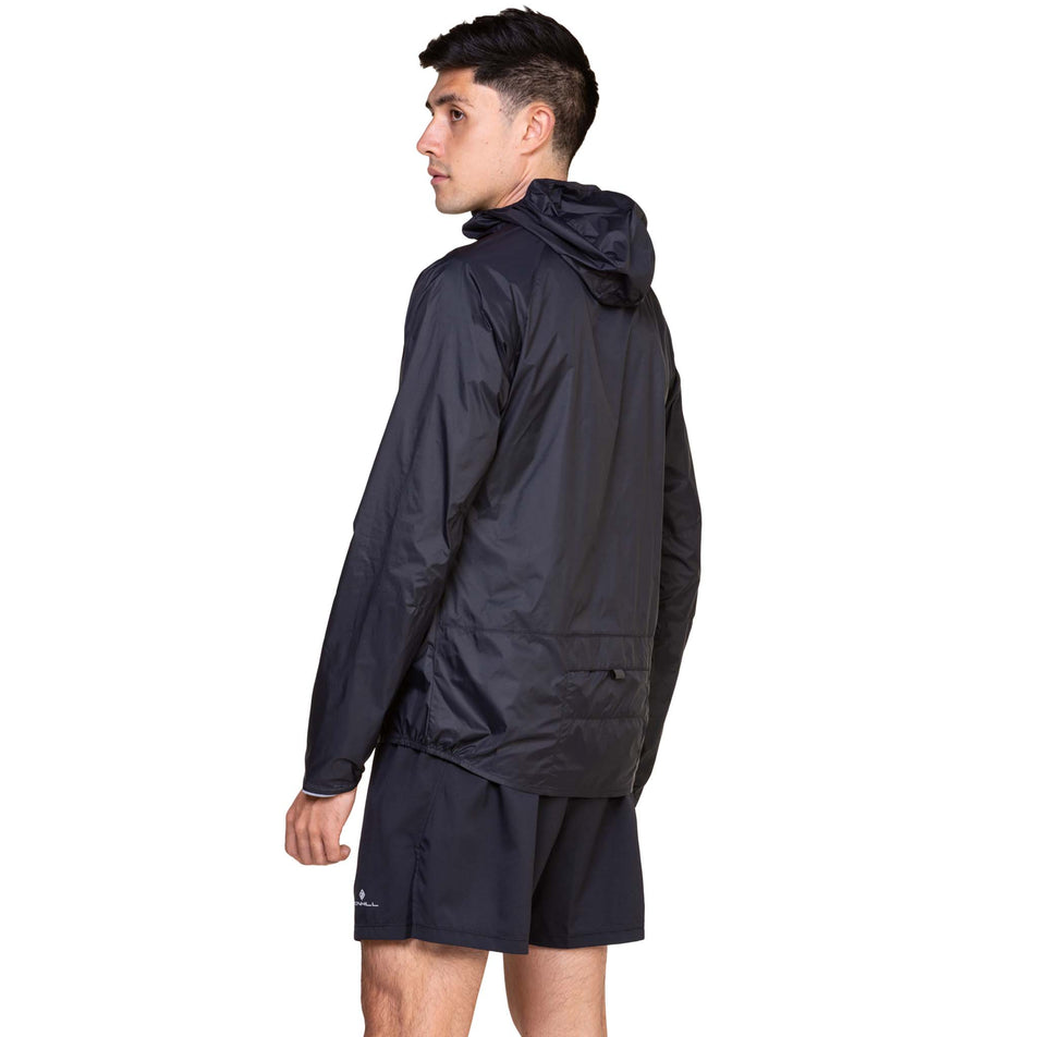 Back view of a model wearing the Ronhill Men's Tech All-Terrain Jacket in the All Black colourway. (8563617431714)