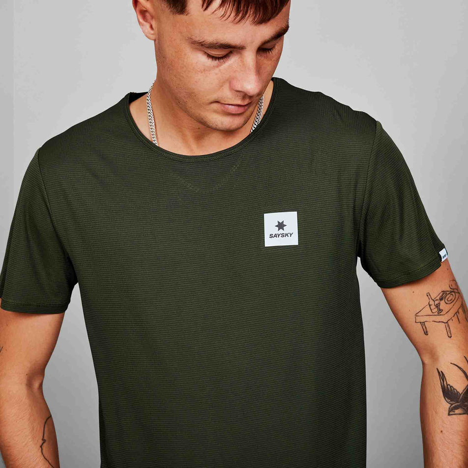 Close-up front view of a model wearing a SAYSKY Men's Clean Flow T-Shirt in the Green colourway. (8628464976034)